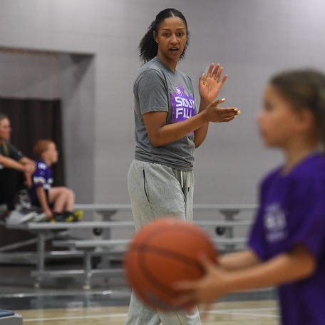 A Phoenix Mercury coach helps out at a clinic on Friday, April 24, in Sioux Falls, South Dakota.