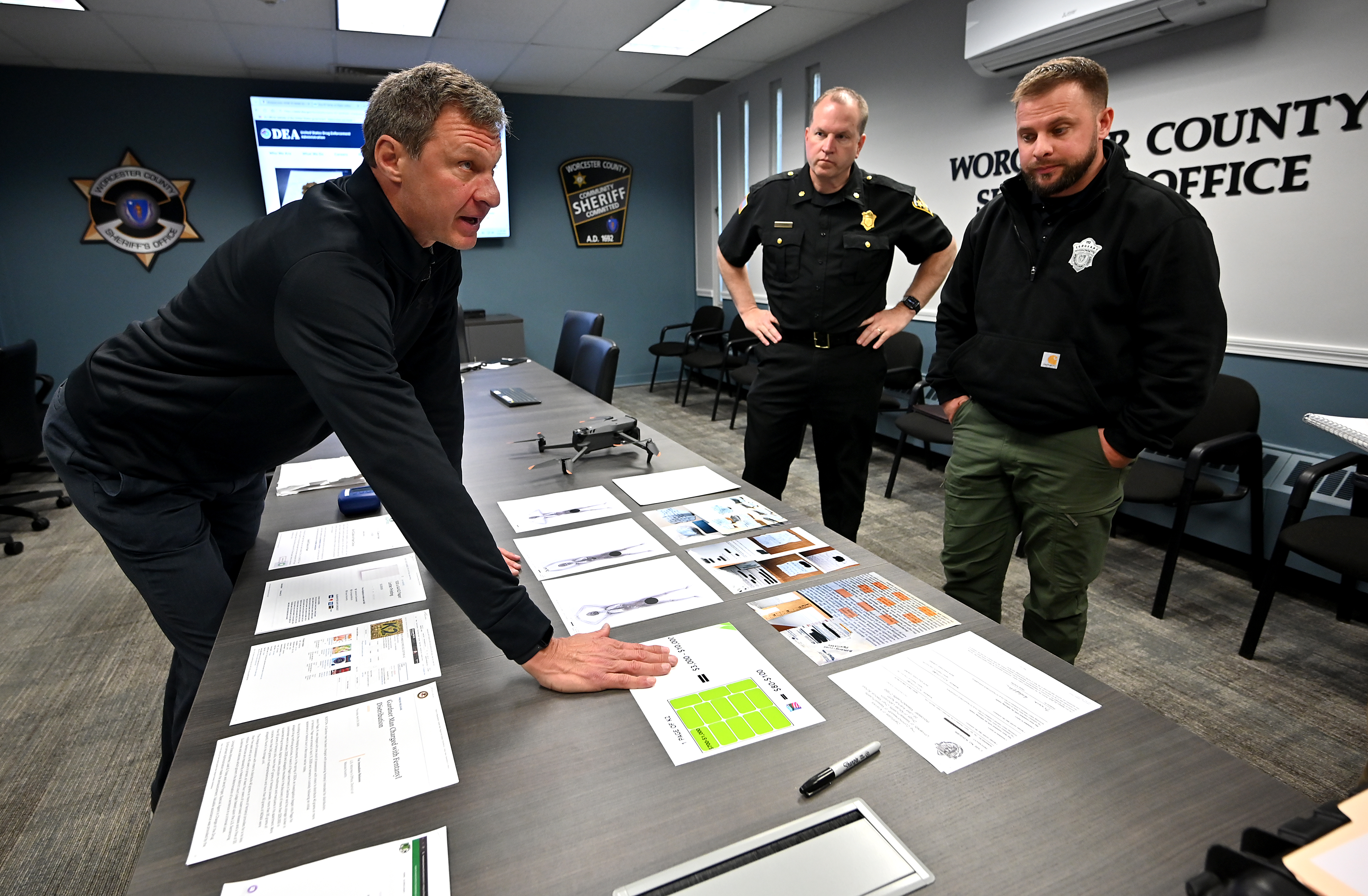 Sheriff Lew Evangelidis and members of his team, Tom Chabot and Sgt. Nicholas Aromando, right, discuss the issue of drugs being sprayed onto pieces of paper and smuggled into the Worcester County Jail & House of Correction.
