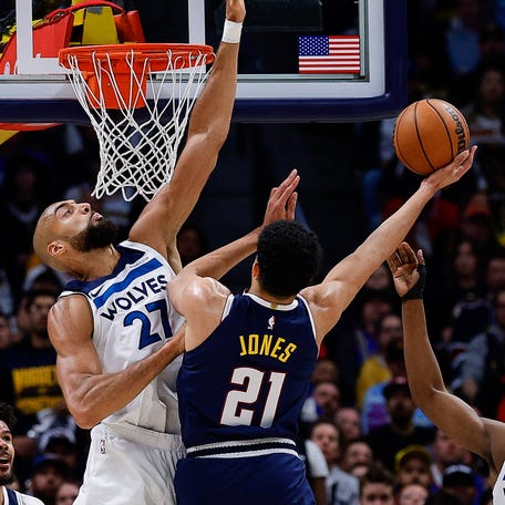 Denver Nuggets forward Spencer Jones (21) drives to the net against Minnesota Timberwolves center Rudy Gobert (27) and guard Ayo Dosunmu (13) as forward Cameron Johnson (23) and guard Jamal Murray (27) and guard Terrence Shannon Jr. (1) defend during the first quarter of Game 5 at Ball Arena on April 27, 2026.