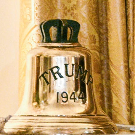 Britain's King Charles III presents a bell with the inscription "Trump 1944" as a gift to US President Donald Trump (out of frame) during a State Dinner in the East Room of the White House in Washington, DC, on April 28, 2026.
