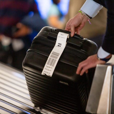 Travelers collect their luggage upon arriving at Sky Harbor International Airport on Nov. 21, 2023.