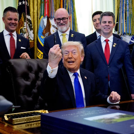 President Donald Trump is pictured holding up a pen as he speaks to reporters after signing executive orders in the Oval Office on April 30, 2026.