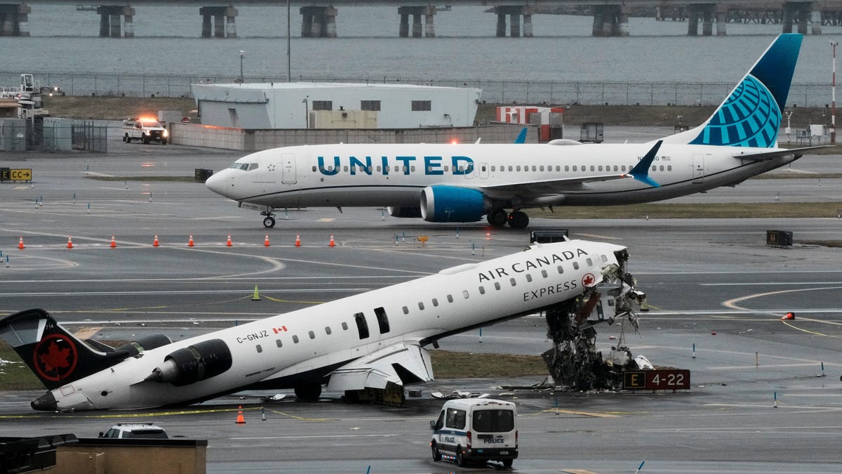 A United Airlines aircraft taxis next to the wreckage of an Air Canada Express jet that collided with a fire truck at New York's LaGuardia Airport in Queens, New York, U.S., March 23, 2026.