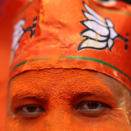 India's ruling Bharatiya Janata Party (BJP) supporter daubed in coloured powder celebrates as early trends show their party leading in the West Bengal state assembly election results, outside the party's regional office in Kolkata, India, May 4, 2026. REUTERS/Sahiba Chawdhary