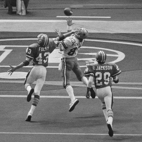 FILE - Despite the effort of Denver Broncos defensive back Steve Foley (43), Dallas Cowboys wide receiver Golden Richards hauls in a touchdown pass during NFL football's Super Bowl 12 in New Orleans on Jan 15, 1978. Richards died Friday, Feb. 23, 2024, of congestive heart failure at his home in Murray, Utah. He was 73. Richards' nephew Lance Richards confirmed his death in a post on his Facebook page. (AP Photo, File)