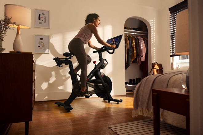 A person using their Peloton exercise bike in their bedroom.