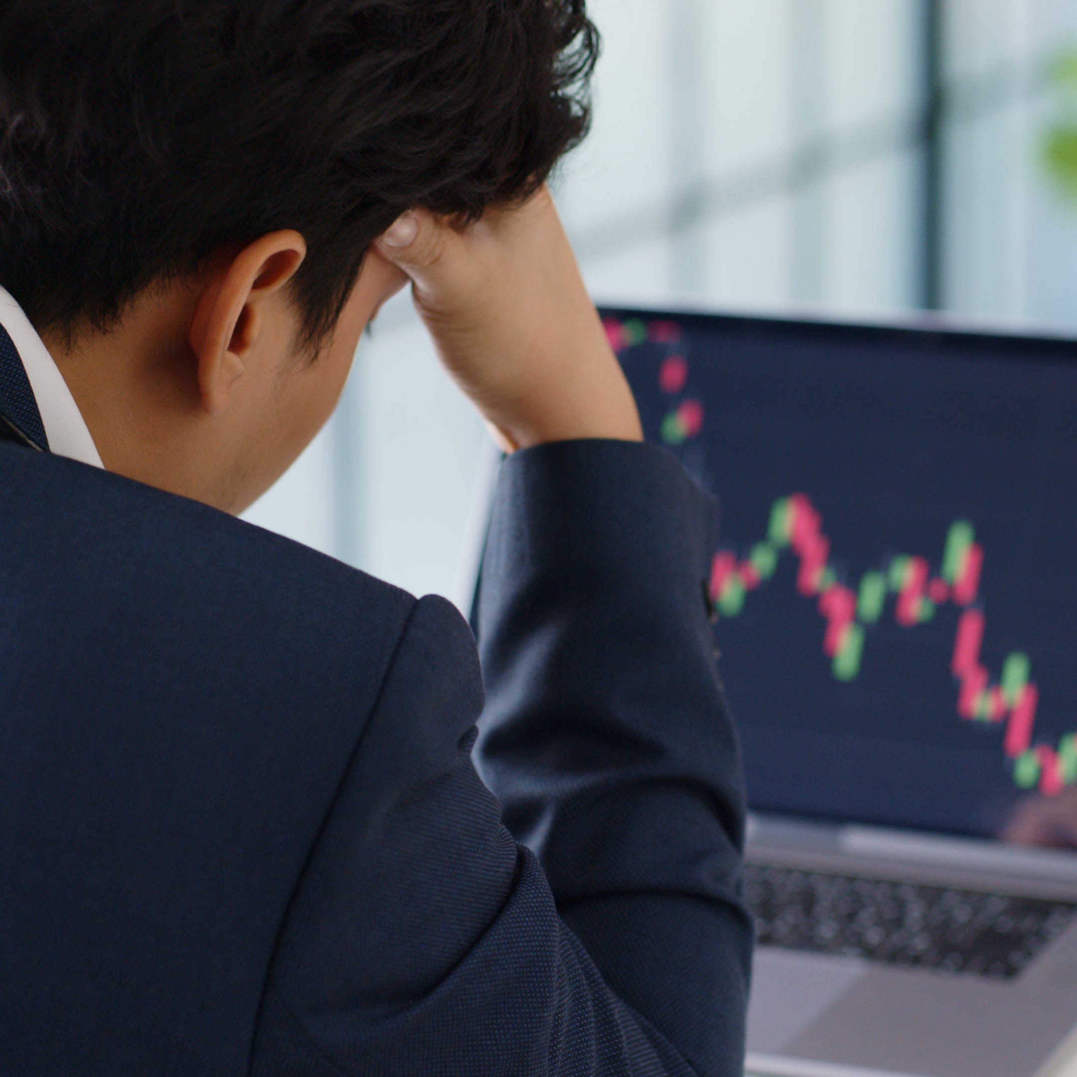 Person looking at downward stock chart on computer.