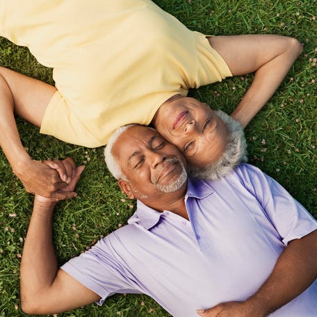 Two people lying on grass.