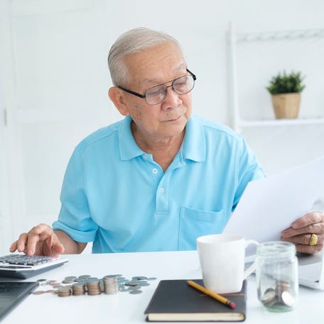 A person at a desk holding a document.