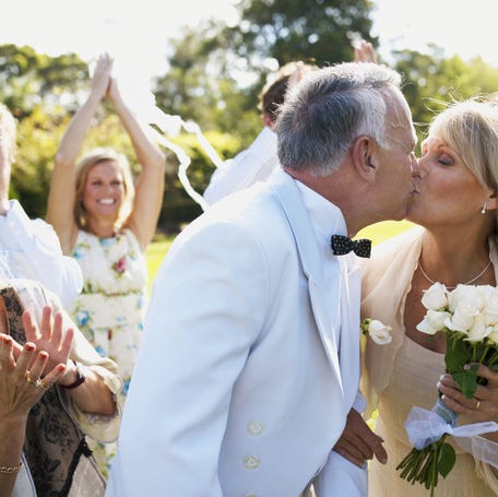 Couple kissing after an outdoor wedding ceremony.