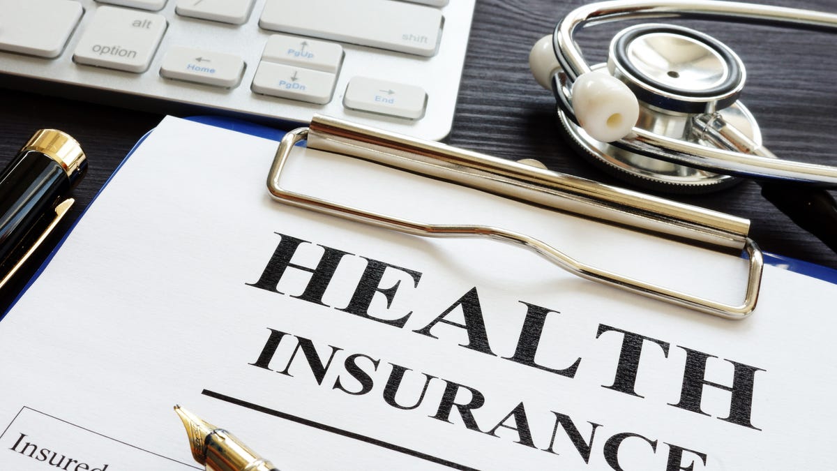 paperwork for health insurance plans on a clipboard.