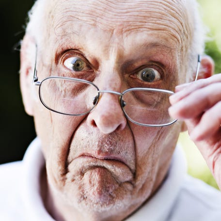 Someone is looking alarmed and is pulling his glasses off his face.