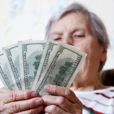 Person counting $100 bills.