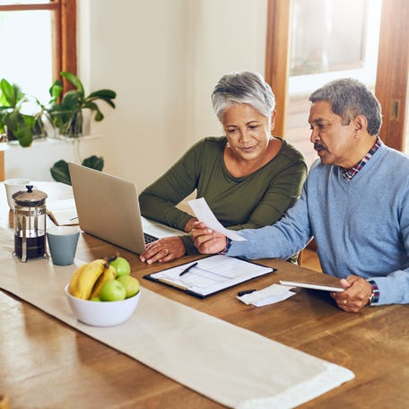 Two people looking at documents while sitting at table.