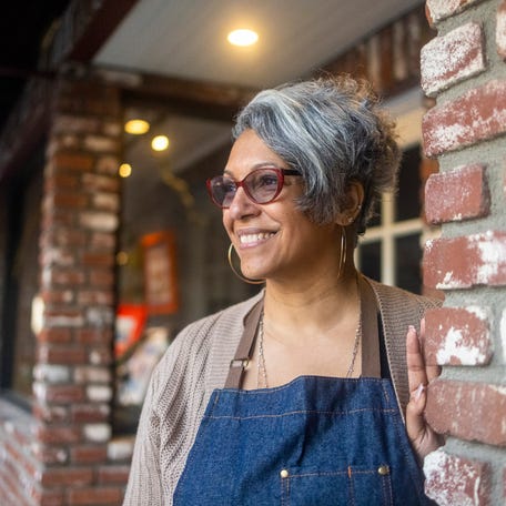A person wearing an apron outside a building.