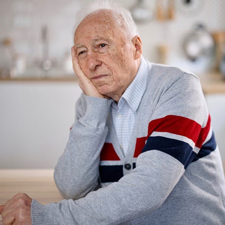 A person with a sad expression at a table.