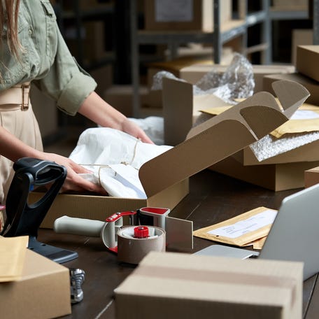 Person packing shipping boxes.