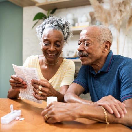 Smiling couple looking at document together.