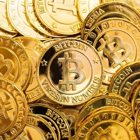 Gold coins with Bitcoin logo on them.