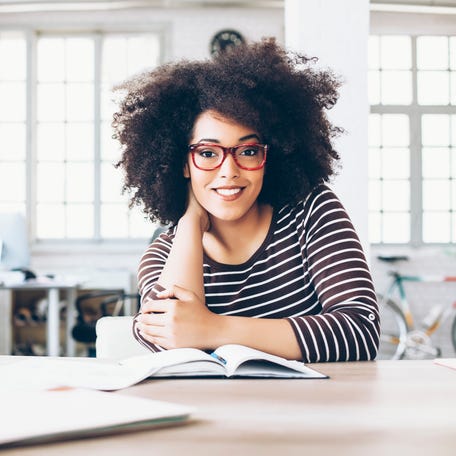A smiling person at a table.