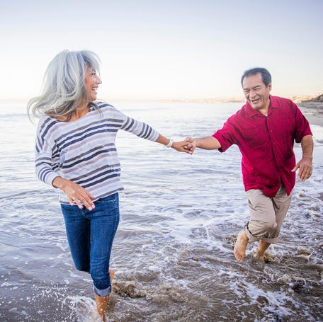 A couple retired walking on the beach.