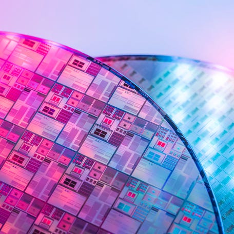 Close-up view of two uncut silicon wafers, full of semiconductor chips.