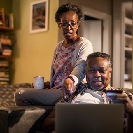 Adults looking at a laptop.