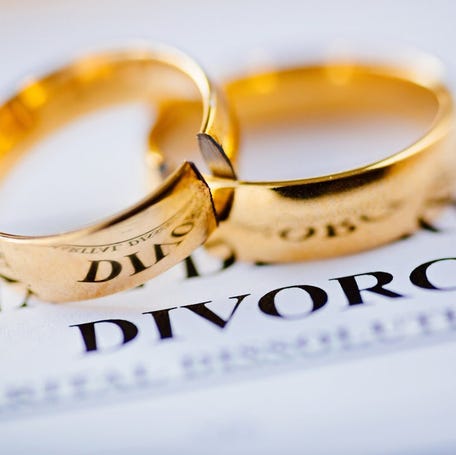 Two wedding rings lying on top of a divorce decree.