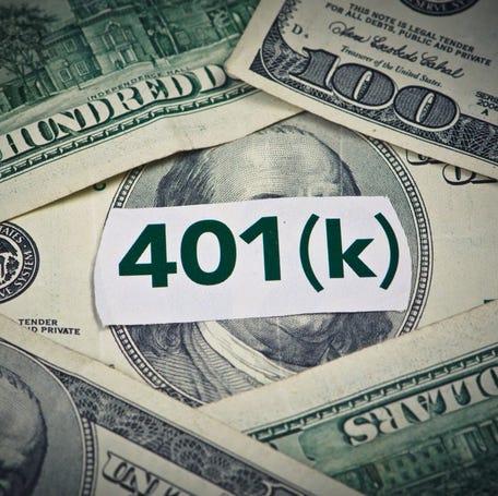 Hundred-dollar bills, with a piece of tape reading "401(k)" on top of the pile.