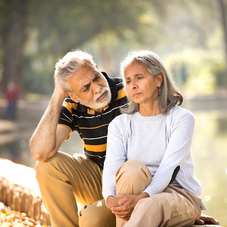 Two people with serious expressions sitting outside.