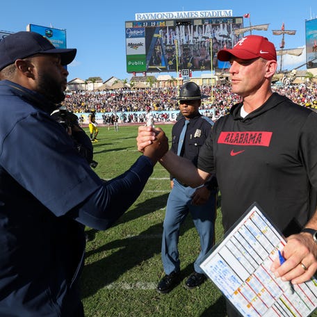 Dec 31, 2024; Tampa, FL, USA; Michigan Wolverines head coach Sherrone Moore greets Alabama Crimson Tide head coach Kalen Deboer after the ReliaQuest Bowl at Raymond James Stadium. Mandatory Credit: Nathan Ray Seebeck-Imagn Images