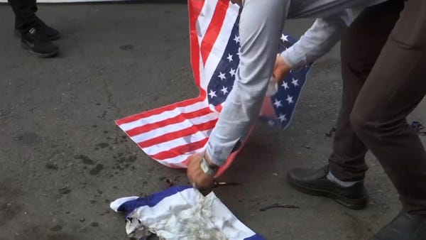 US flags burnt at Iran demo as Biden tours Mideast