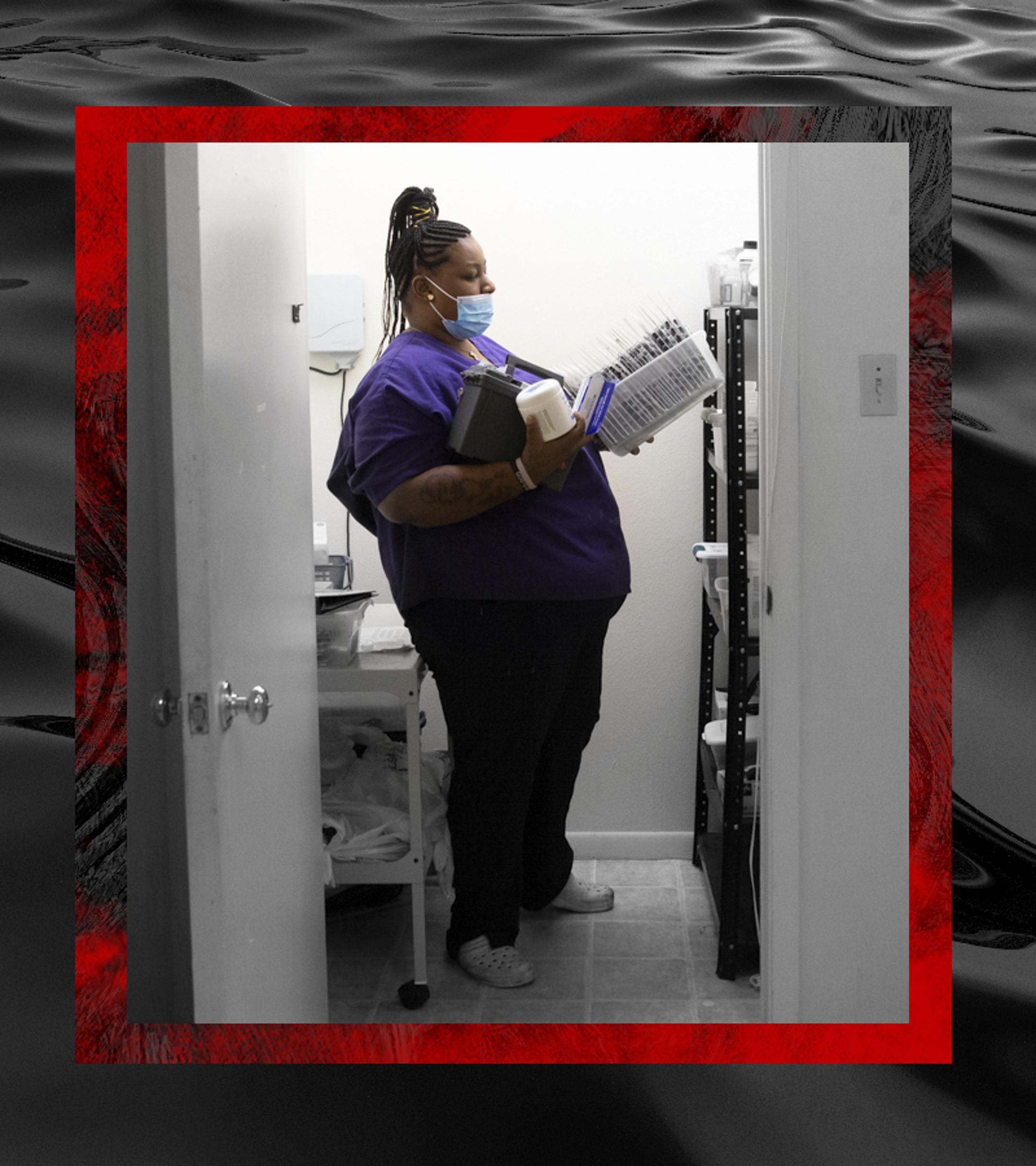 Tre'Asia Anderson gets her clients' medication out of hte locked closet where it is kept; her arms are full. The camera captures her from a doorway. The photo is desaturated except for Tre'Asia. A square of dark and red water border the photograph.