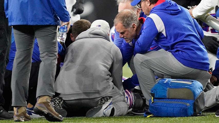 NFL athletic trainers tend to Damar Hamlin after he collapsed during a game