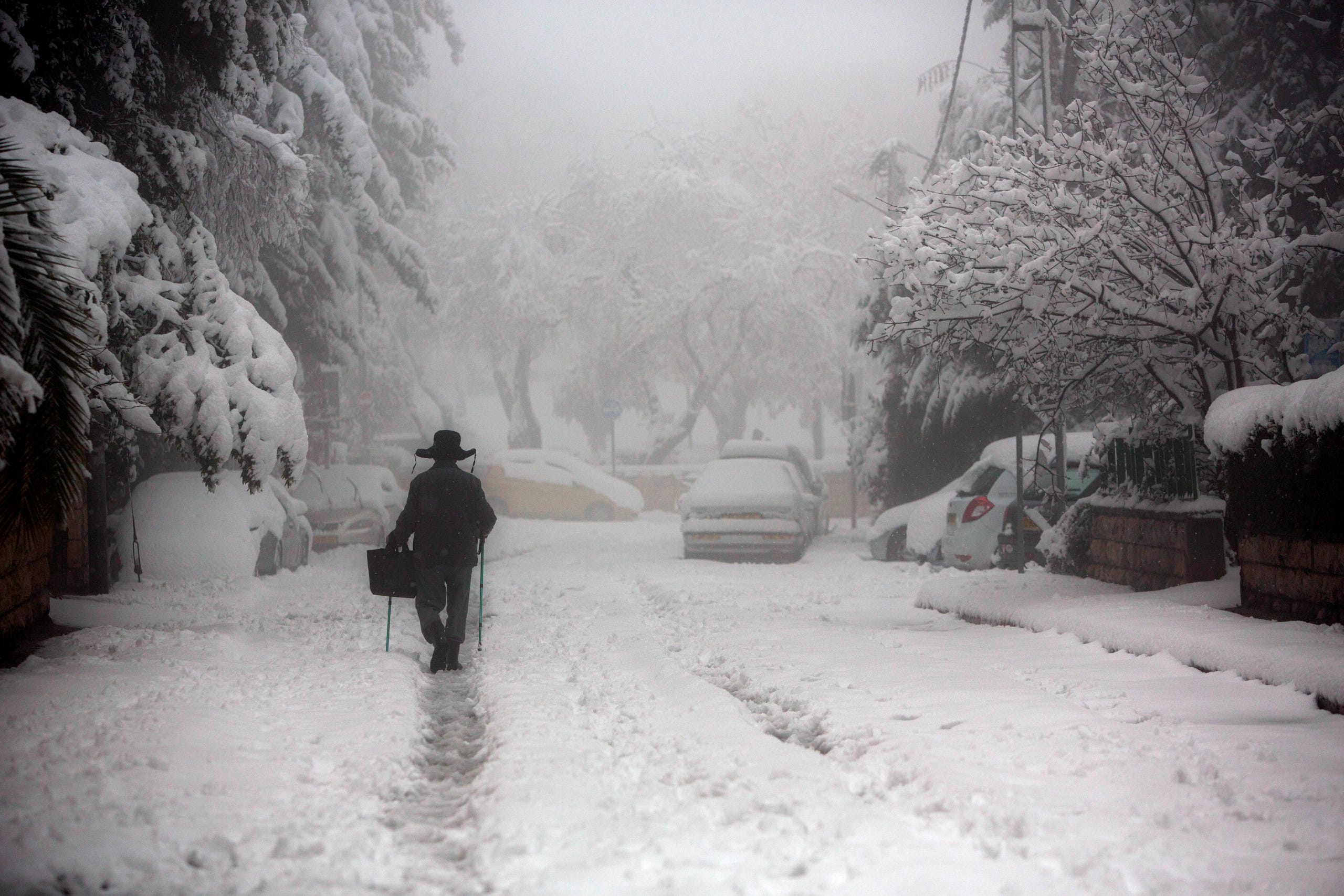 A man walks in the snow in Jerusalem.