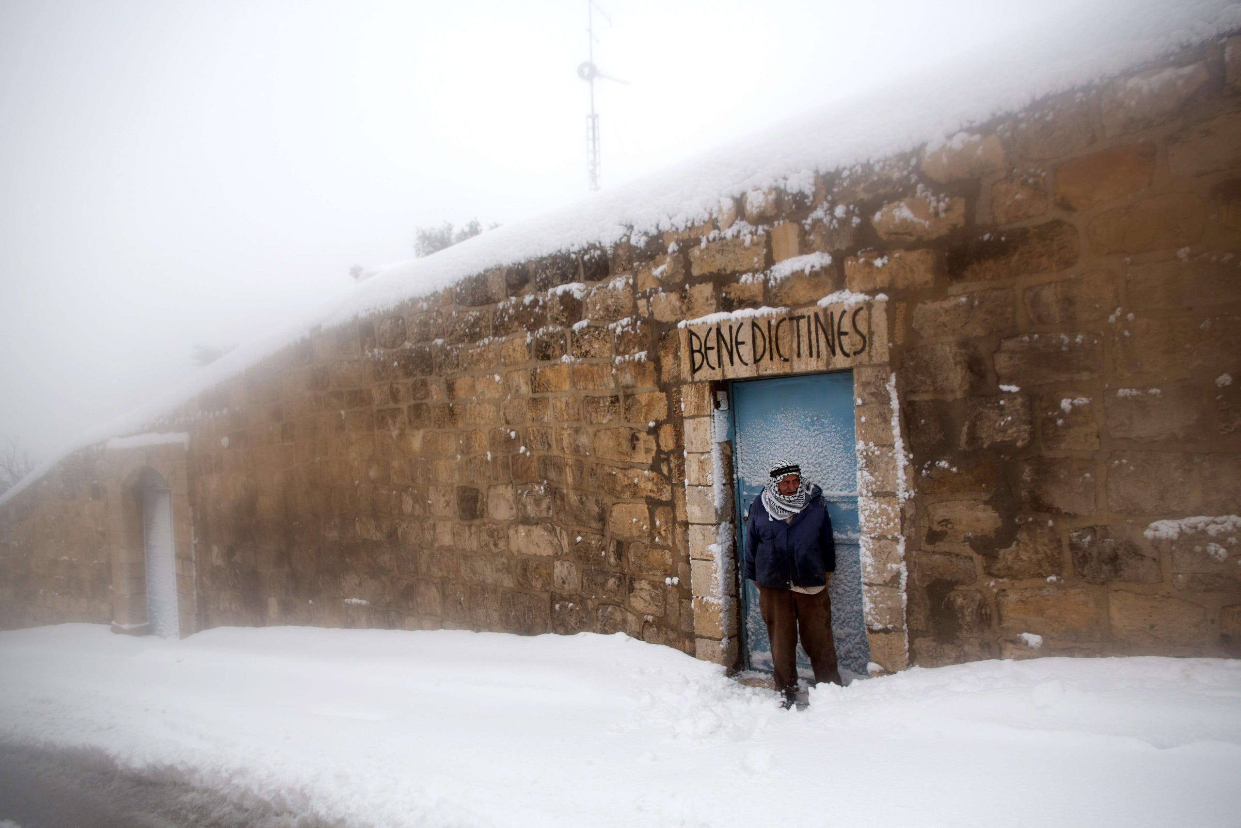 A Palestnian man stands in the snow in east Jerusalem following a heavy storm.