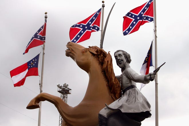 The statue of Nathan Bedford Forrest is surrounded by Confederate and state flags.