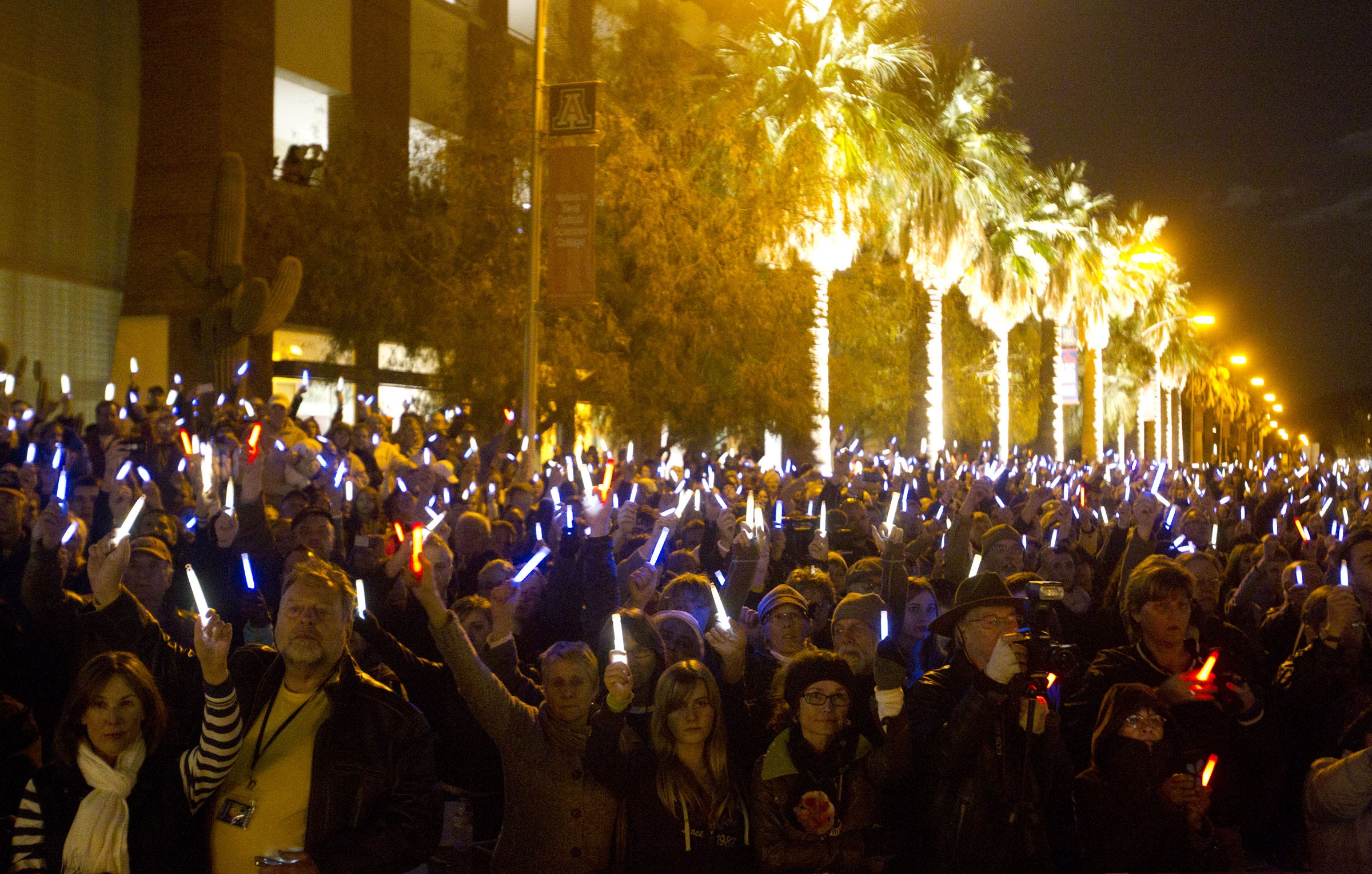 JANUARY 2012: People raise their glow sticks during a vigil at the University of Arizona in Tucson, marking the one-year anniversary of the shootings at the Safeway near Tucson.