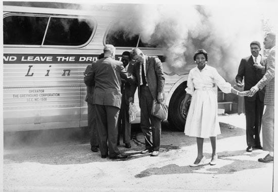 Freedom Riders exit bus firebombed in Anniston, Alabama, by Ku Klux Klan-led mob on May 14, 1961. The riders were challenging segregations laws in the South.
