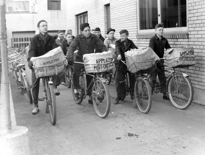 Post-Crescent newspaper carriers ride away from the building to start their routes in 1939.
