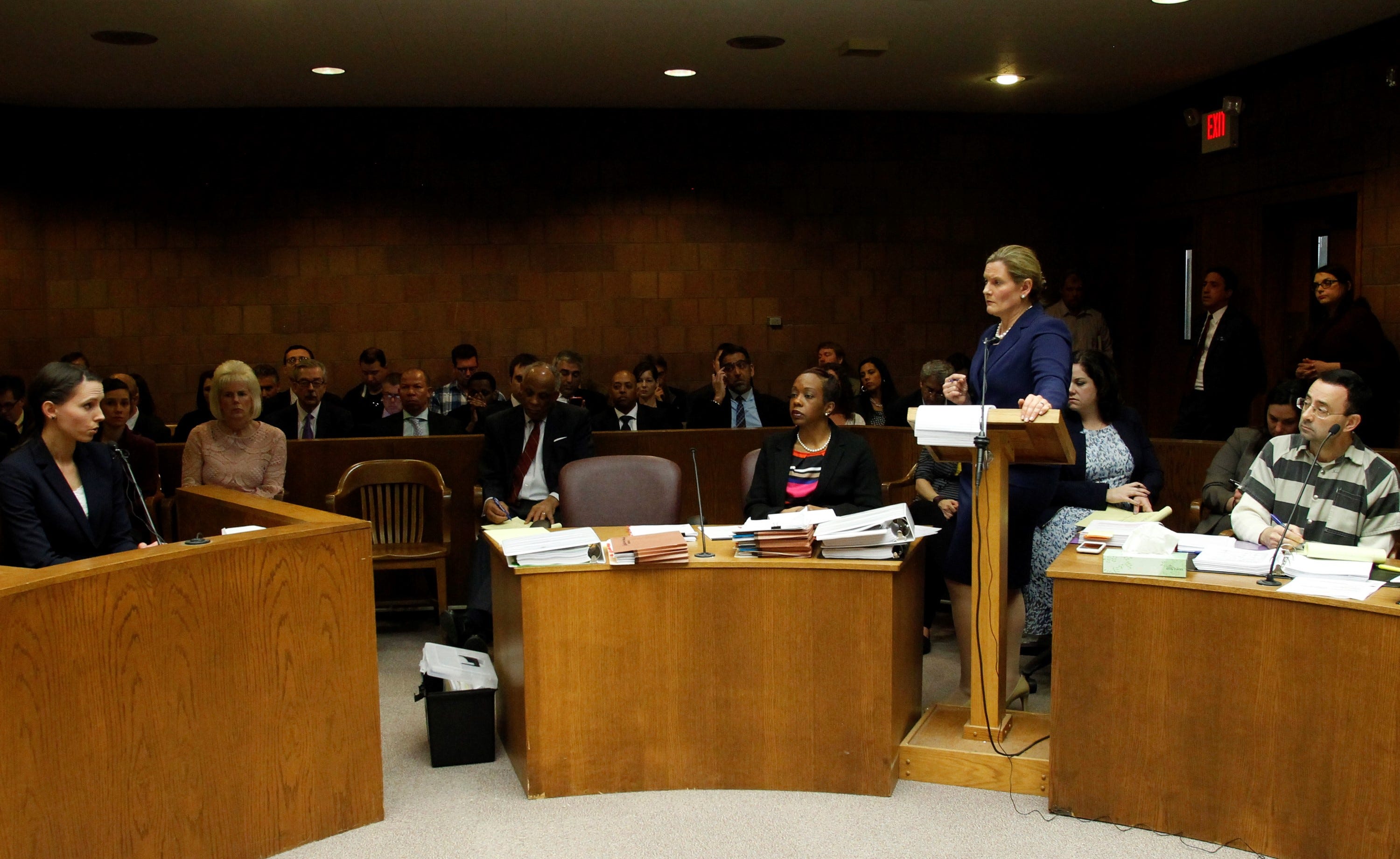 Rachael Denhollander answers questions from Assistant Attorney General Angela Povilaitis during a preliminary hearing for Larry Nassar in 55th District Court in Mason, Michigan on May 12, 2017. Nassar is seated just behind Povilaitis..