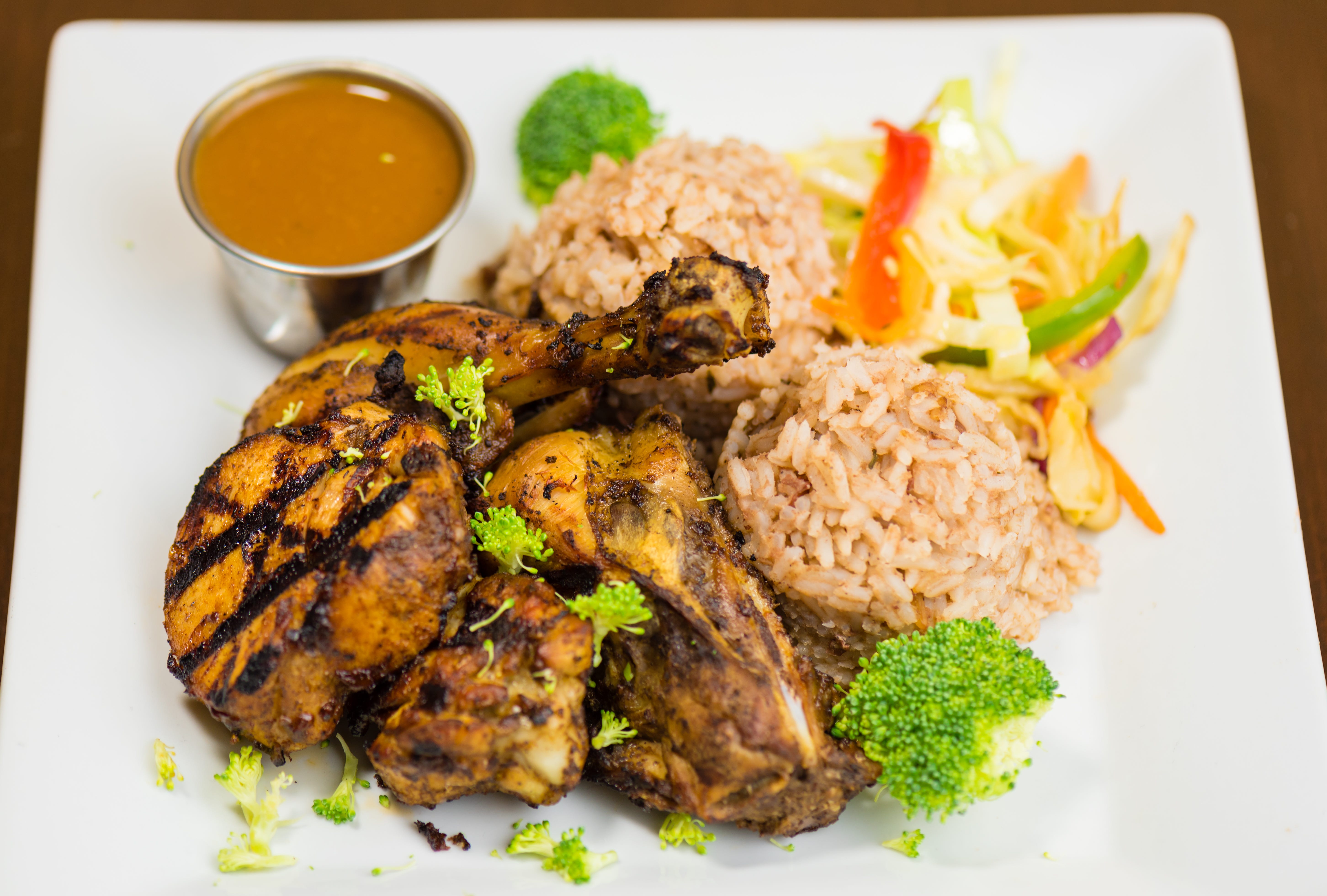 Jerk chicken, a specialty of Jamaica, is dry rubbed or marinated in a hot spice mixture, and then slow-cooked. The word "jerk" is said to come from charqui, a Spanish term of Quechua origin for dried meat — also the basis for the English word "jerky."  This platter is from Simply Jerk in Monroe Township, New Jersey.