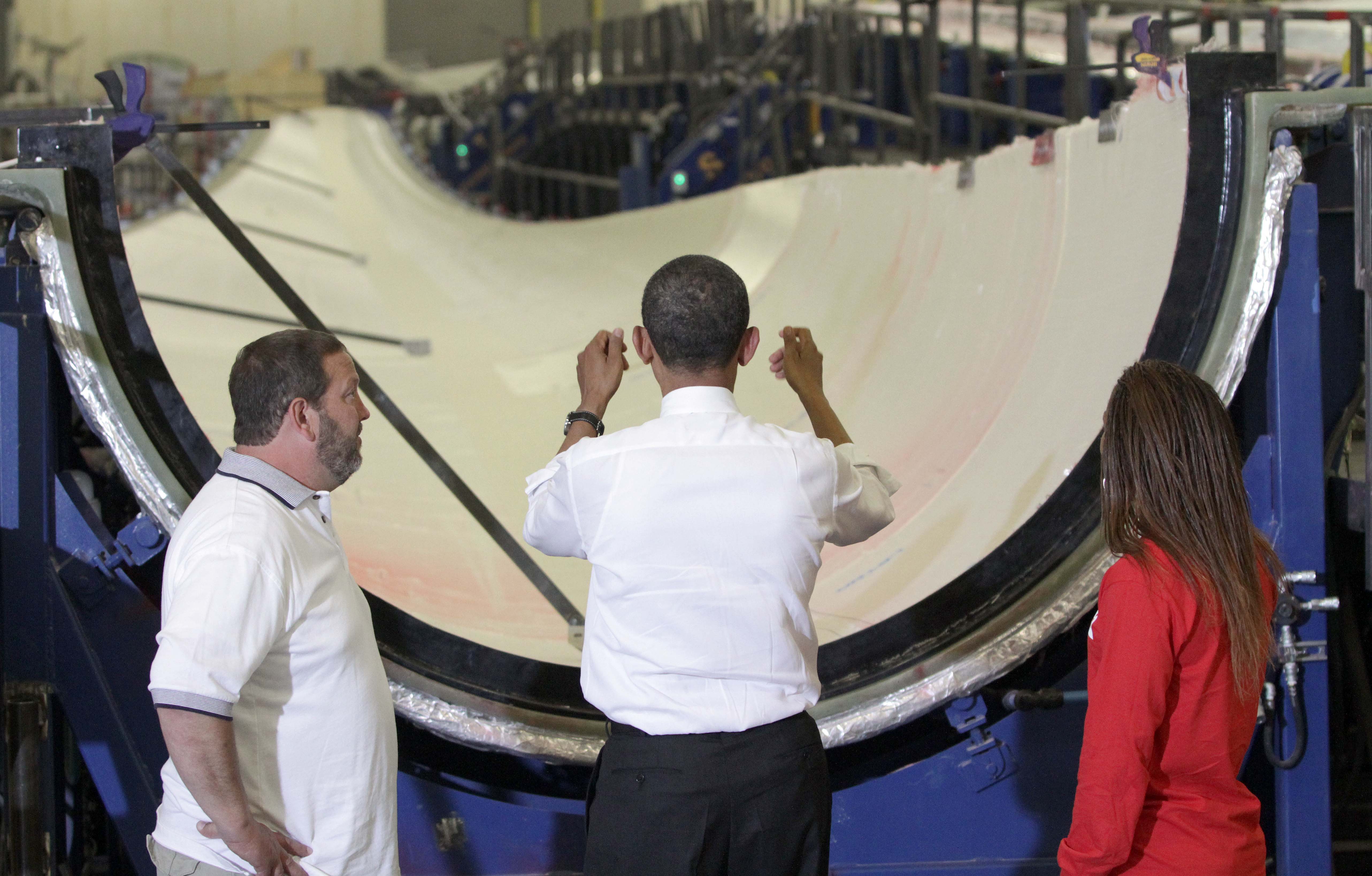 President Barack Obama examines a wind turbine blade in 2012 during a tour of TPI Composites in Newton, Iowa. The Rhode Island company opened the factory in a former Maytag appliance factory to supply the many wind turbines across the state.