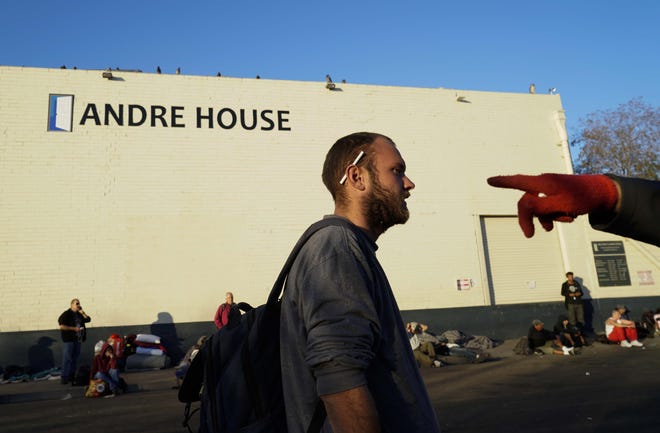 Homeless men and women wait in line outside Andre House for a free meal prepared by volunteers.