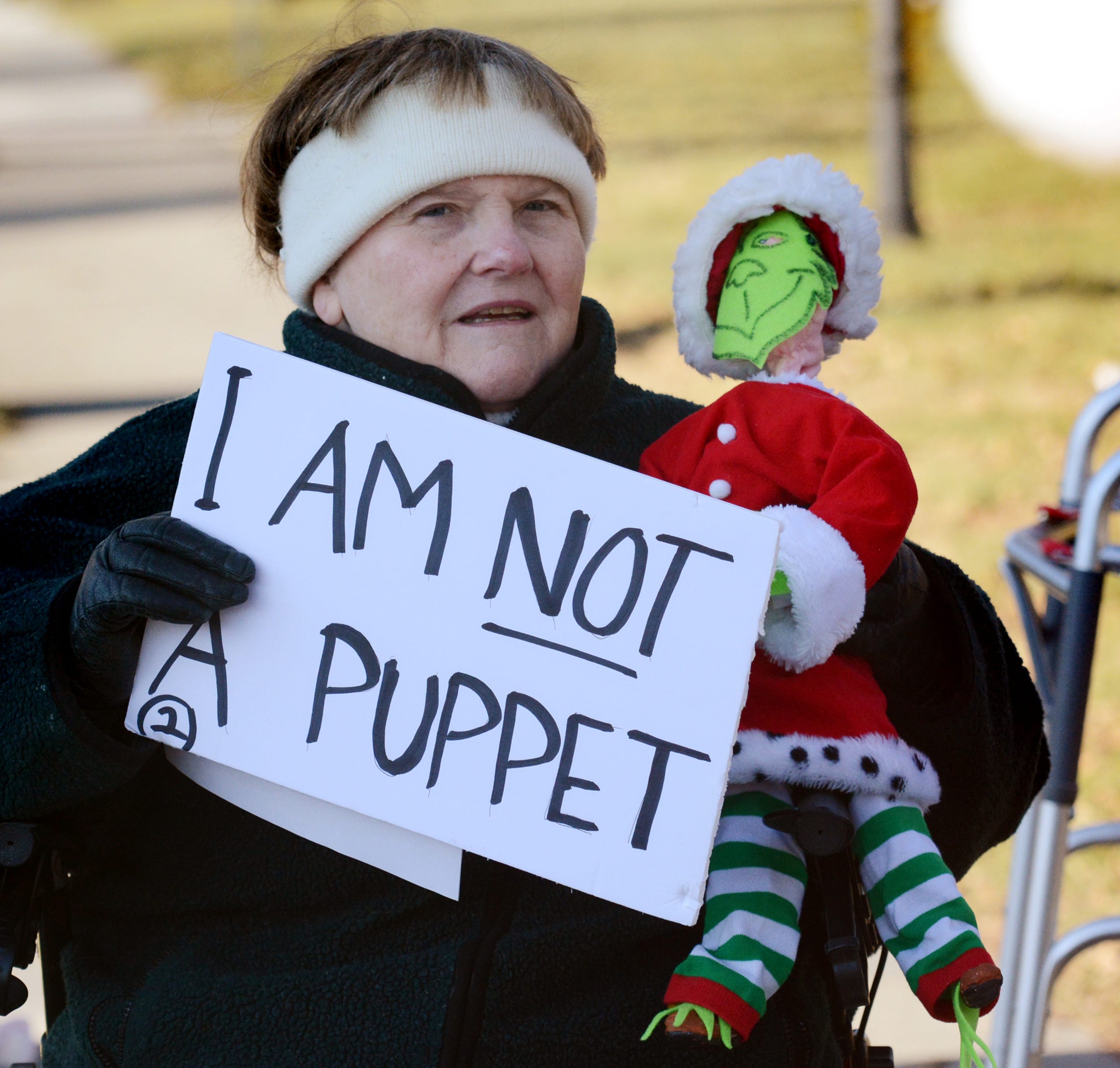 Indivisible York organizer Marta Peck holds a sign during a 