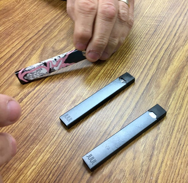 Hamilton County Sheriff's Department Deputy Brad Osswald holds one of three Juul devices he has confiscated this year from students at Hamilton Heights High School. The e-cigarettes contain nicotine, and have become popular among teens in Hamilton County.