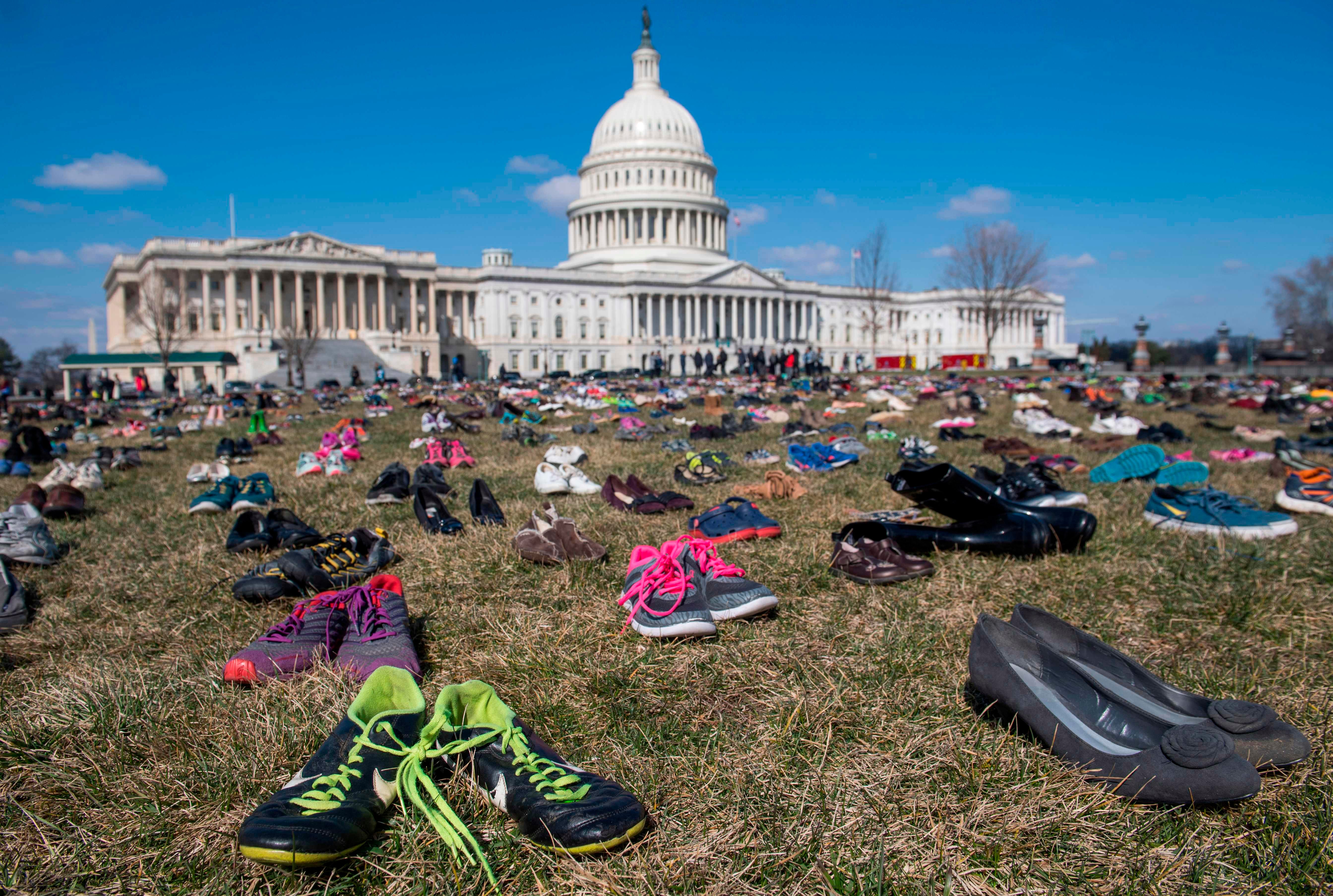 The lawn outside the US Capitol is covered with 7,000 pairs of empty shoes to memorialize the 7,000 children killed by gun violence since the Sandy Hook school shooting, in a display organized by the global advocacy group Avaaz, in Washington, DC, Ma