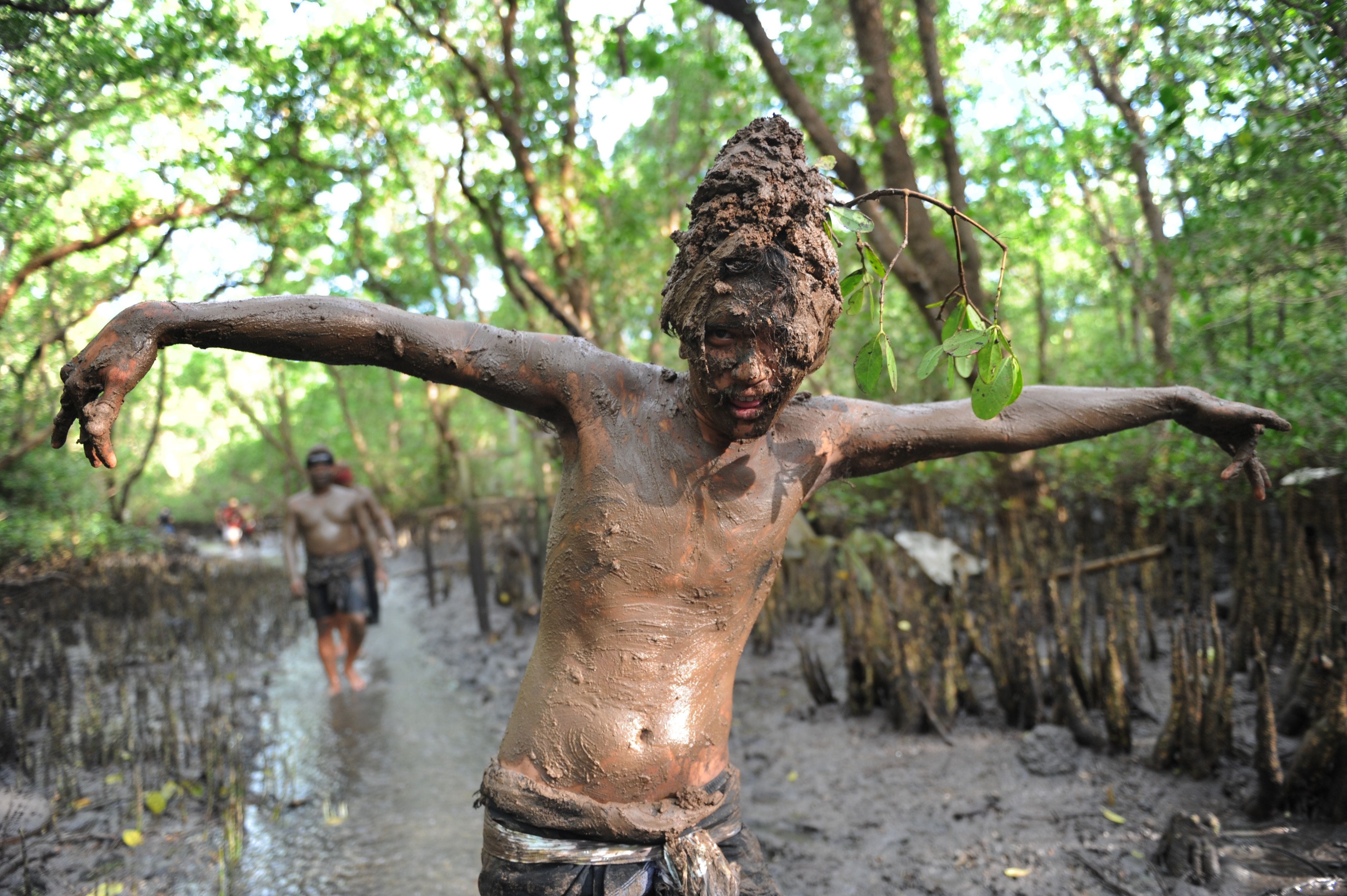 A Balinese boy puts mud on his body during a traditional mud baths known as Mebuug-buugan, in Kedonganan village, near Denpasar on Indonesia's resort island of Bali on March 18, 2018. The Mebuug-buugan is held a day after Nyepi aimed at neutralizing 