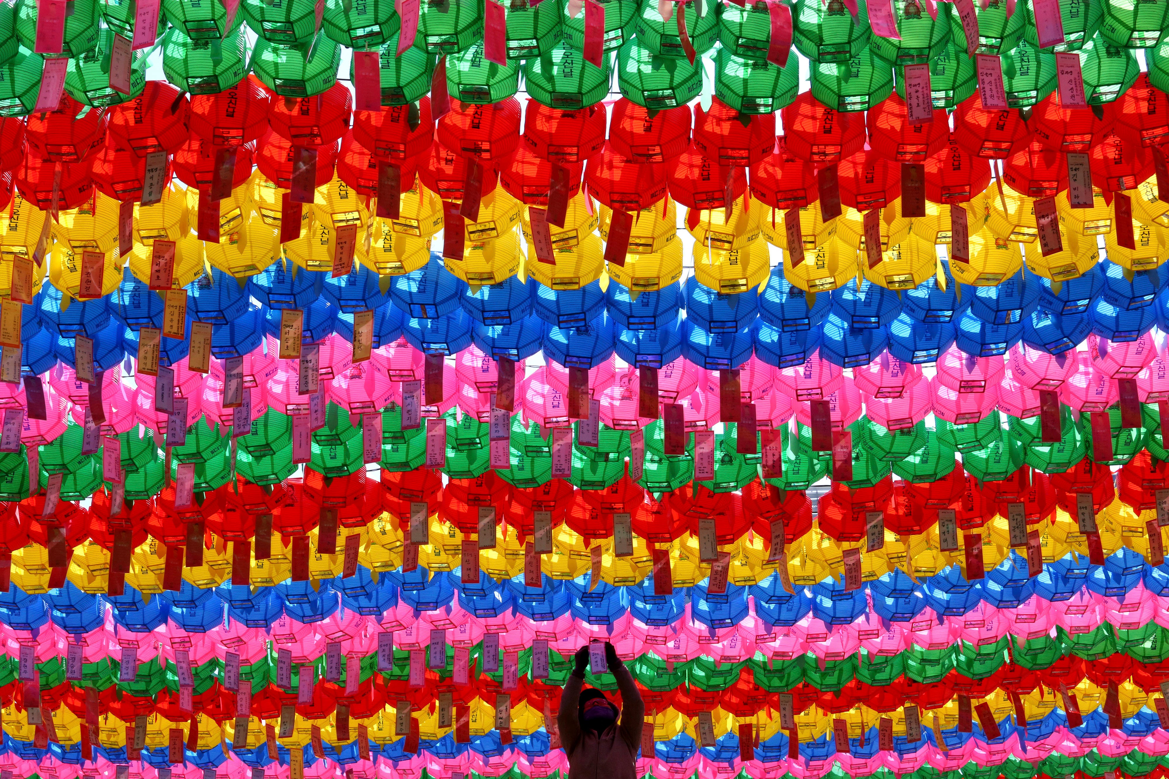 A worker attaches a name tag to a lantern of a Buddhist who made donation for the upcoming celebration of Buddha's birthday on May 22 at the Jogye temple in Seoul, South Korea. Similar lanterns will be displayed in all Buddhist temples around South K