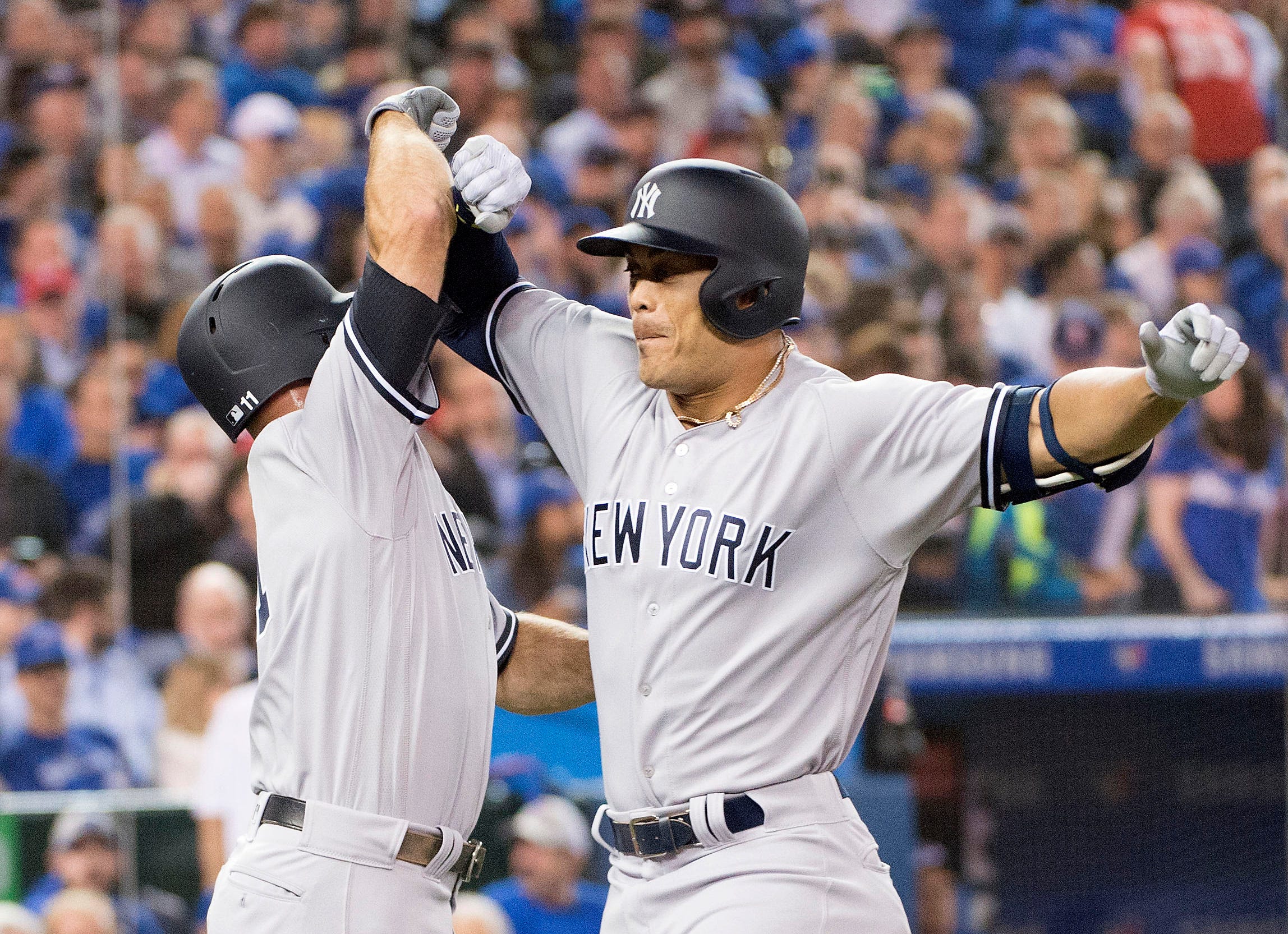 New York Yankees right fielder Giancarlo Stanton, right, celebrates a two run home run in the first inning with New York Yankees left fielder Brett Gardner during the Toronto Blue Jays home opener at Rogers Centre in Toronto.